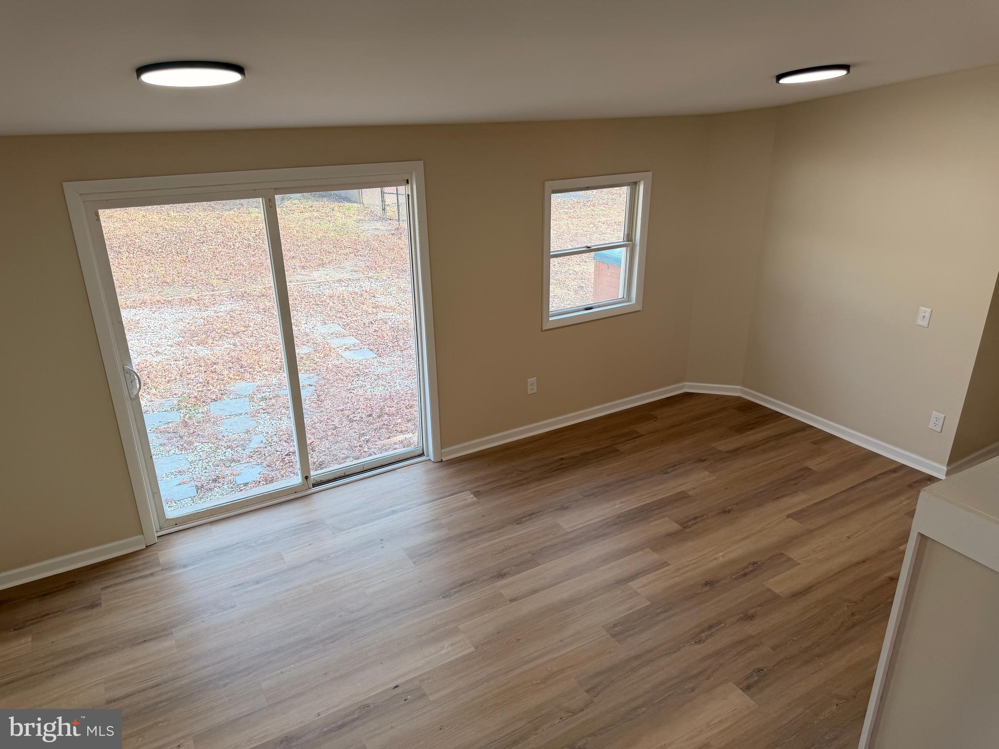 21184 Colton Point Road Avenue, MD 20609 - Photo 5 of 20 an empty room with wooden floor and windows