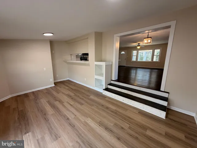 a view of wooden floor fire place and windows in a room