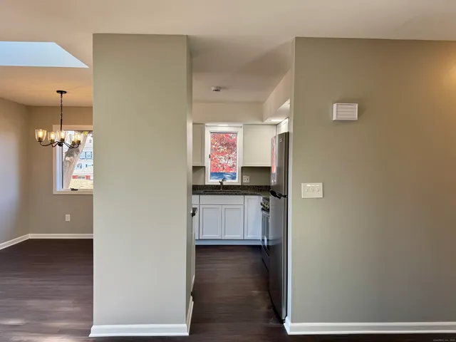 a view of a hallway to room with wooden floor