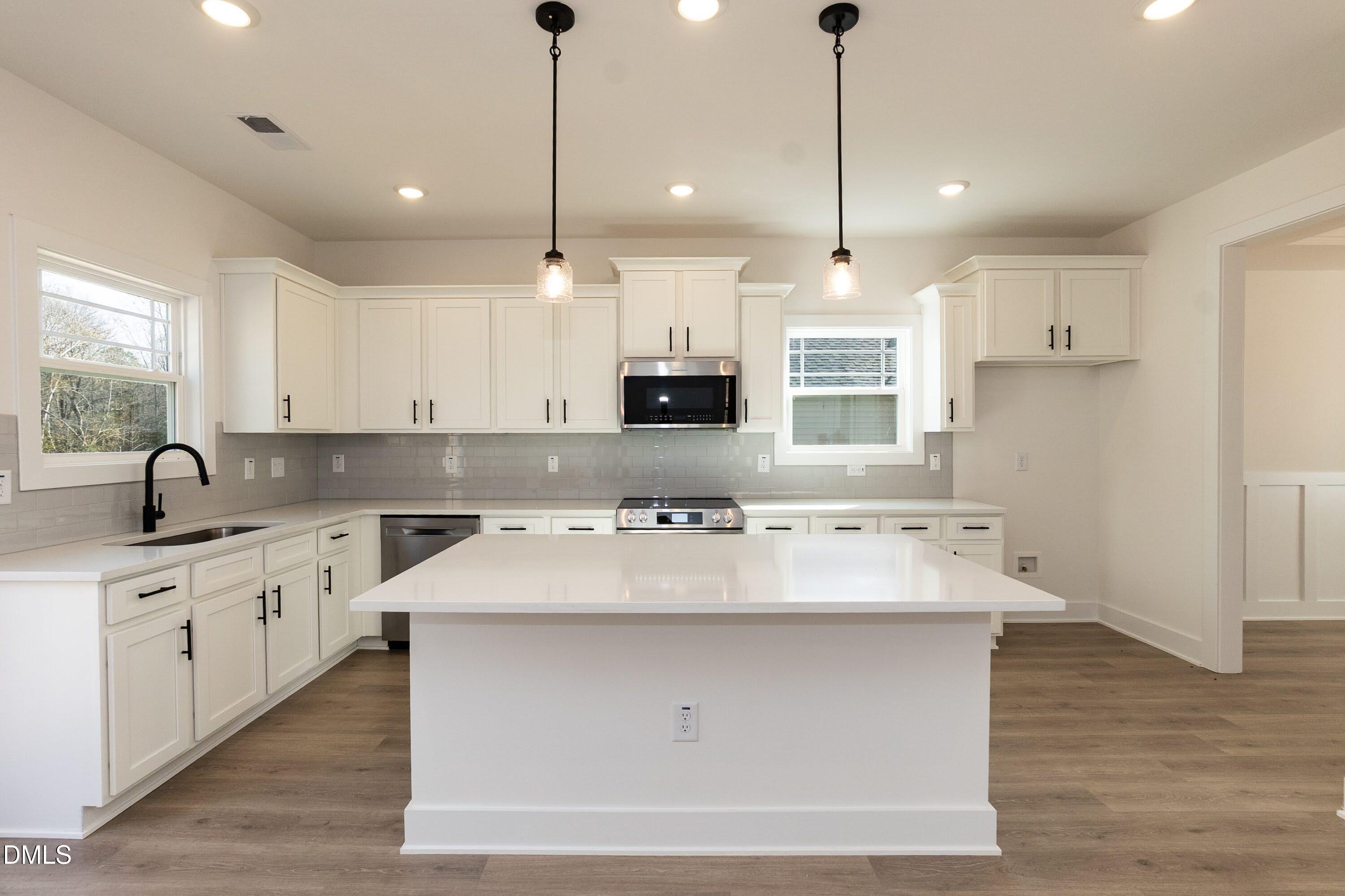 42 Braddock Court Garner, NC 27529 - Photo 12 of 56 a kitchen with kitchen island white cabinets and sink