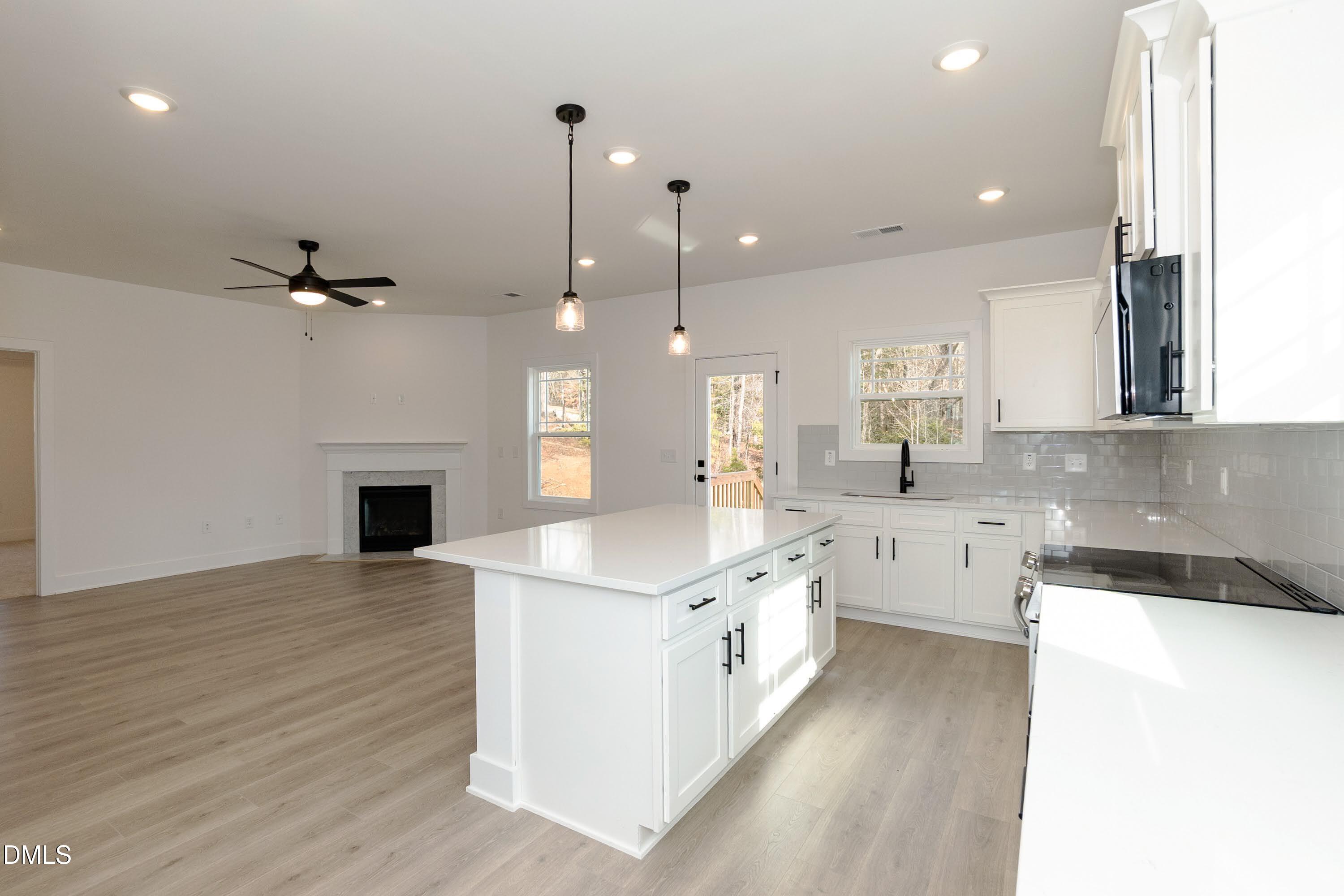 42 Braddock Court Garner, NC 27529 - Photo 14 of 56 a large kitchen with granite countertop a stove top oven a sink a dining table and chairs