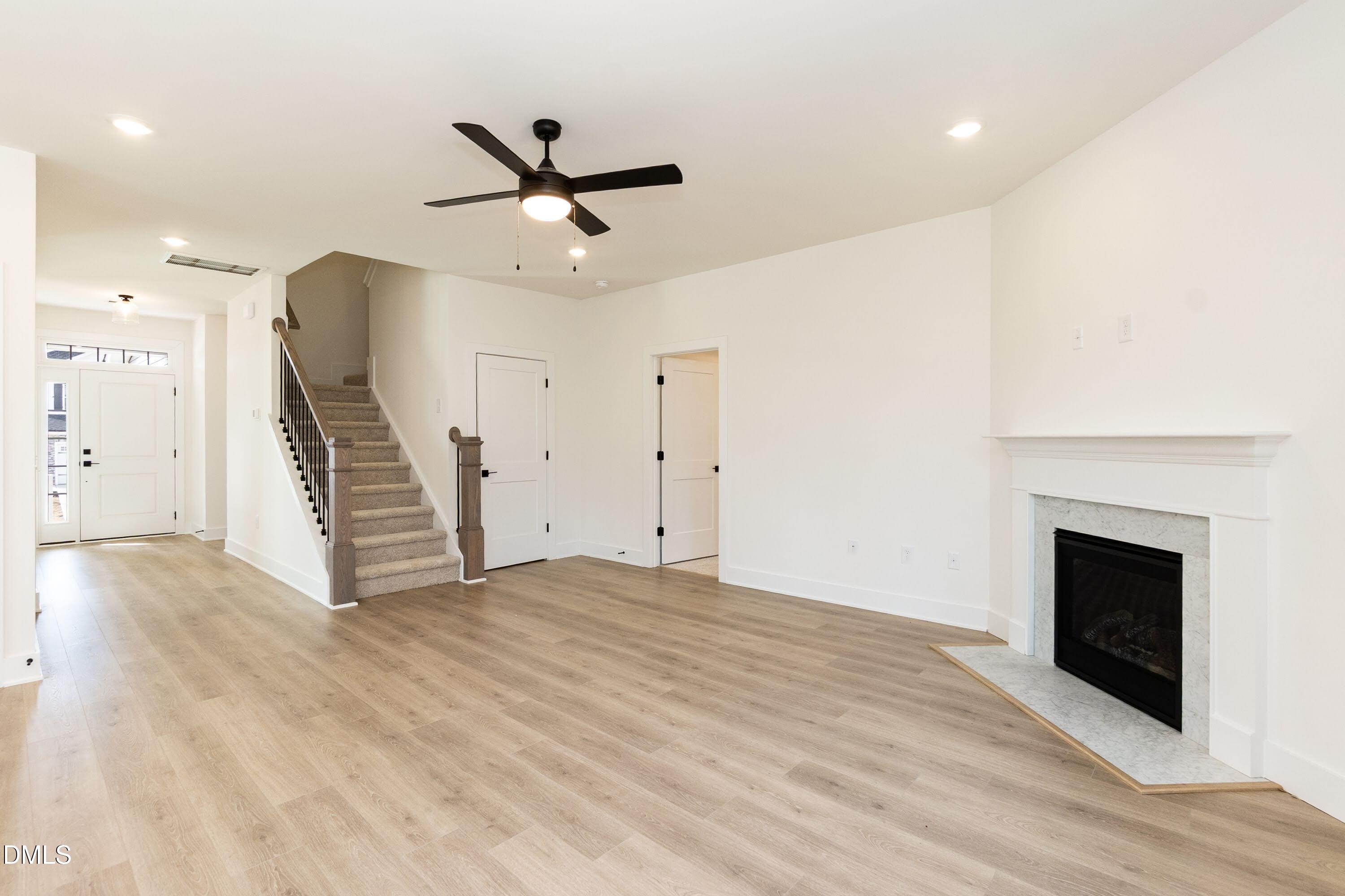 42 Braddock Court Garner, NC 27529 - Photo 17 of 56 a view of an empty room with wooden floor a ceiling fan and a fireplace