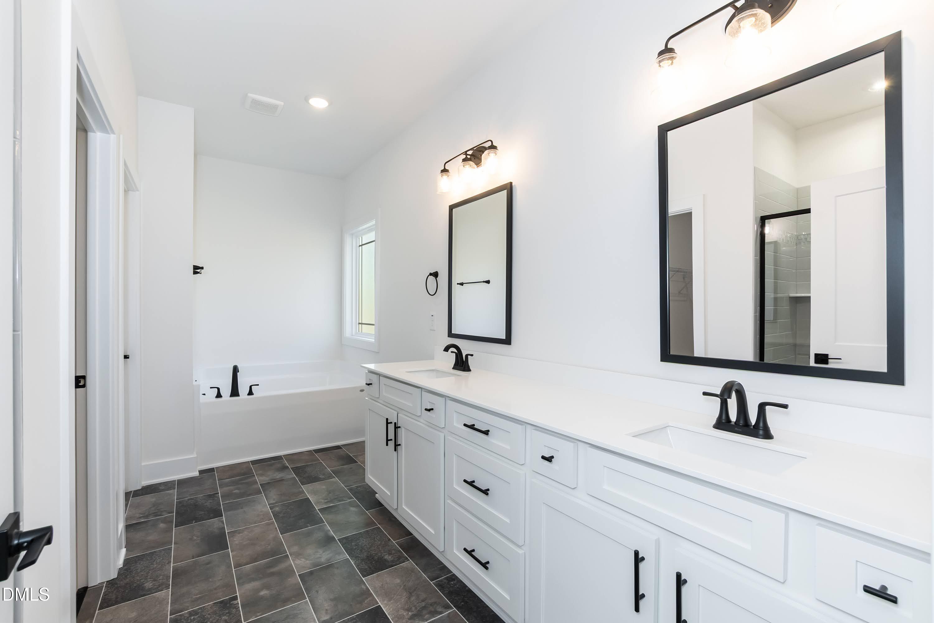 42 Braddock Court Garner, NC 27529 - Photo 21 of 56 a bathroom with a double vanity sink mirror and bathtub