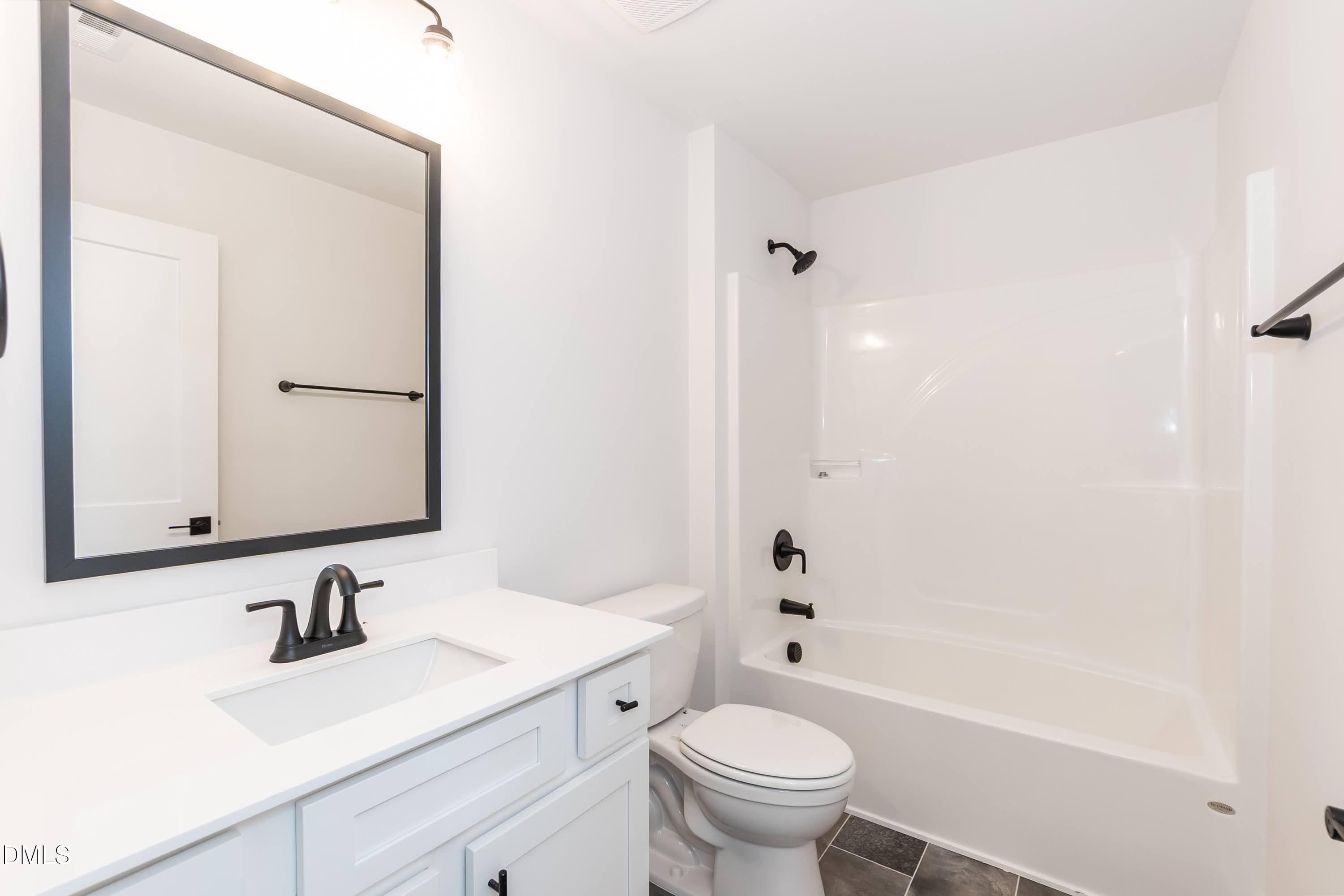 42 Braddock Court Garner, NC 27529 - Photo 31 of 56 a bathroom with a sink toilet a mirror and shower