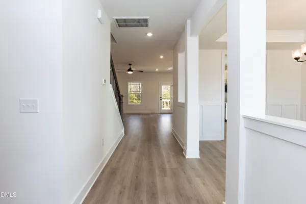 a view of a hallway with wooden floor and staircase
