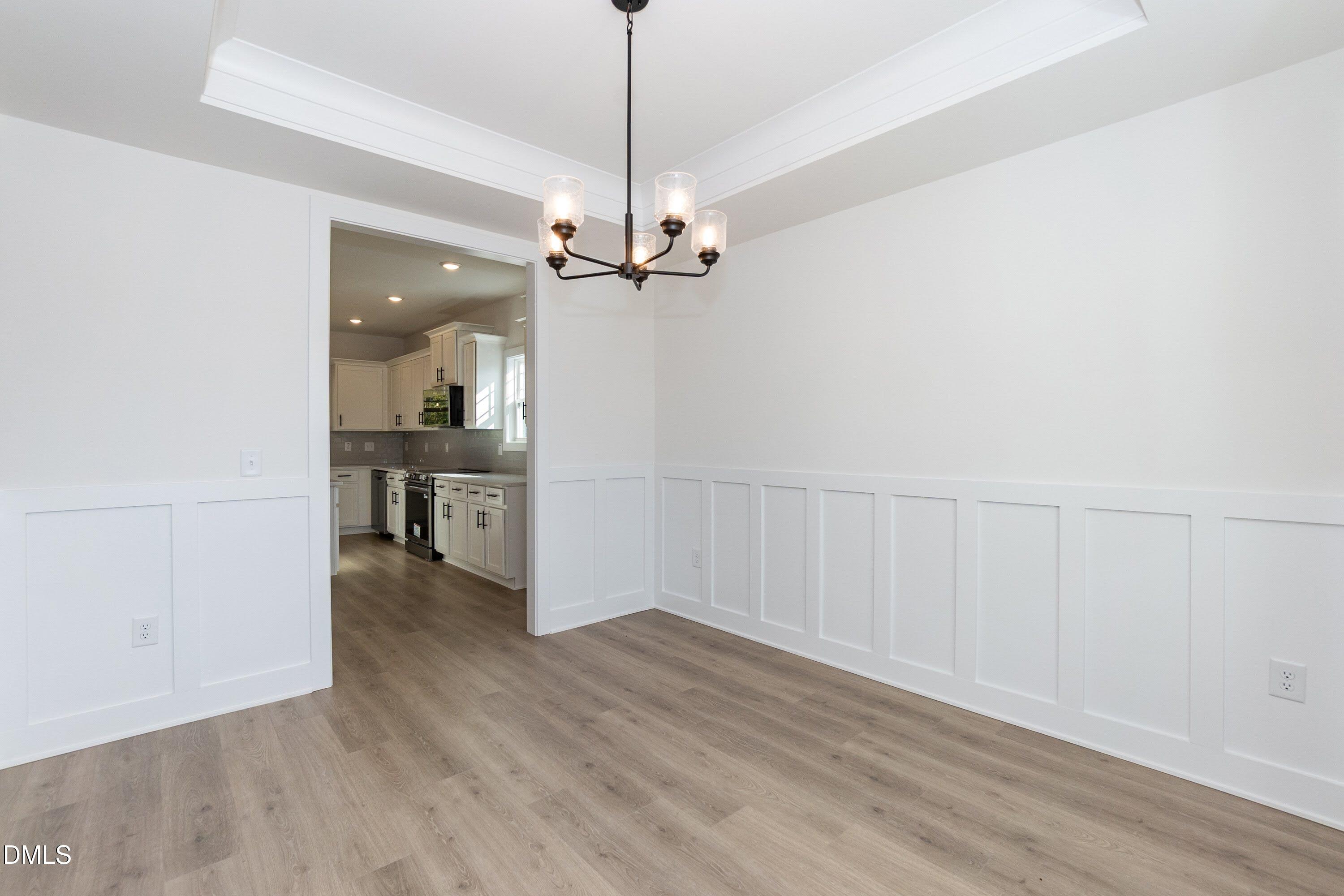 42 Braddock Court Garner, NC 27529 - Photo 10 of 56 a view of a room with wooden floor a ceiling fan and kitchen space