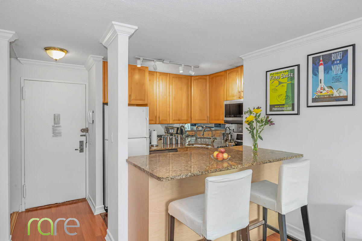 340 East 93rd Street, Unit 23G Manhattan, NY 10128 - Photo 4 of 16 a kitchen with a table chairs refrigerator and sink