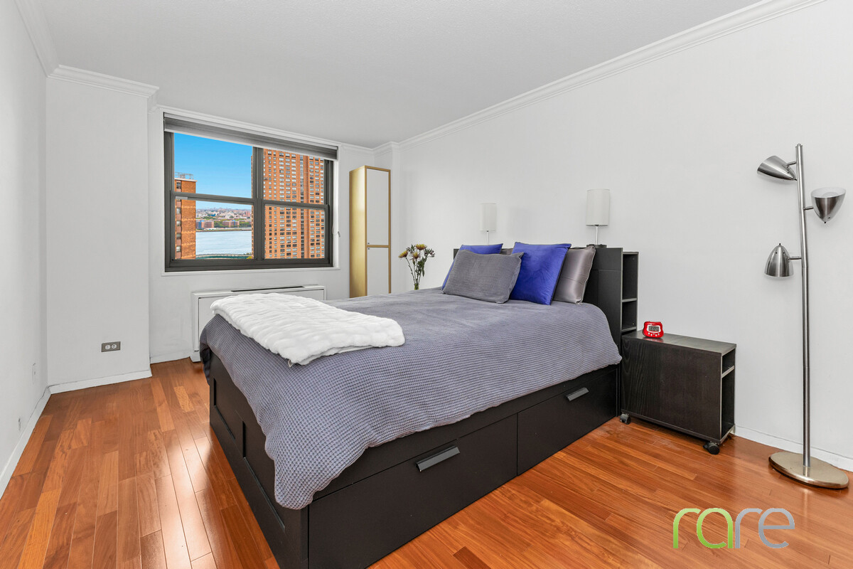 340 East 93rd Street, Unit 23G Manhattan, NY 10128 - Photo 6 of 16 a bedroom with a bed and a night stand