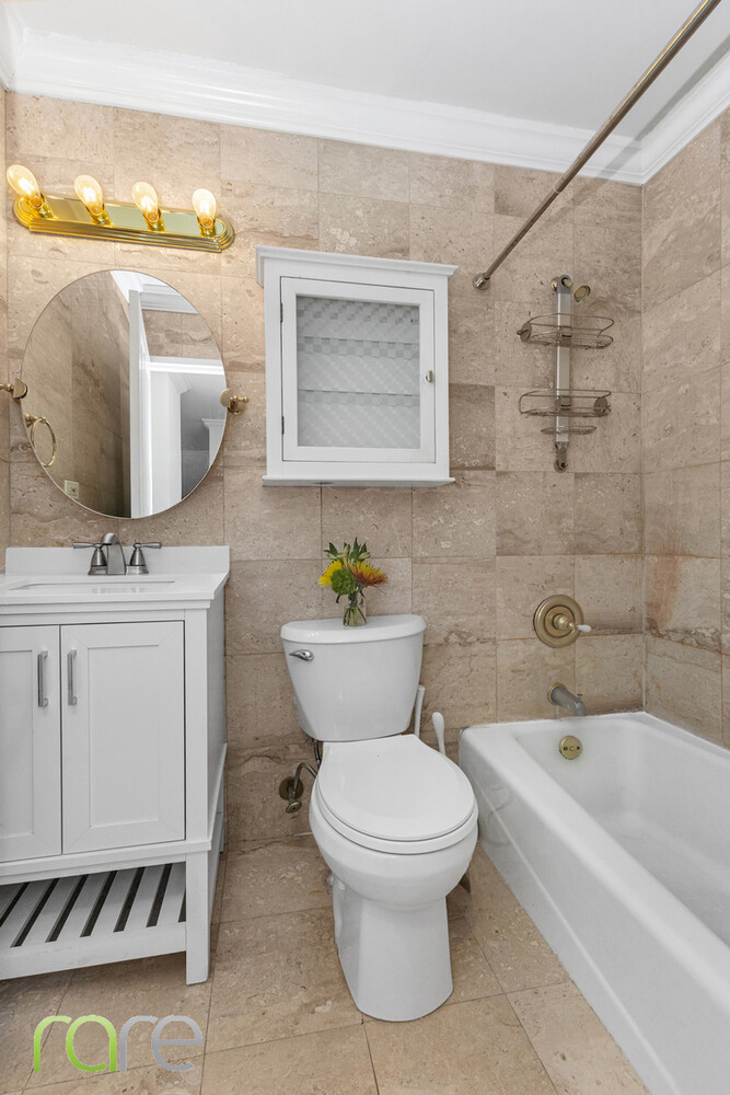 340 East 93rd Street, Unit 23G Manhattan, NY 10128 - Photo 8 of 16 a bathroom with a toilet sink and mirror