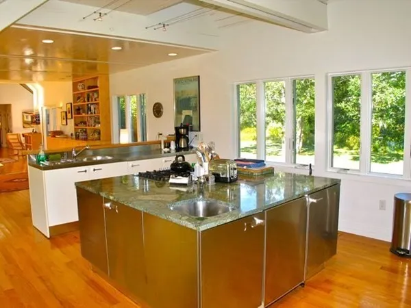a kitchen with kitchen island granite countertop a sink and a large window