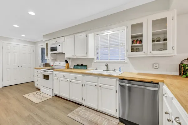 a kitchen with granite countertop white cabinets and white appliances