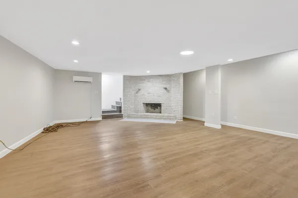 an empty room with wooden floor and fireplace