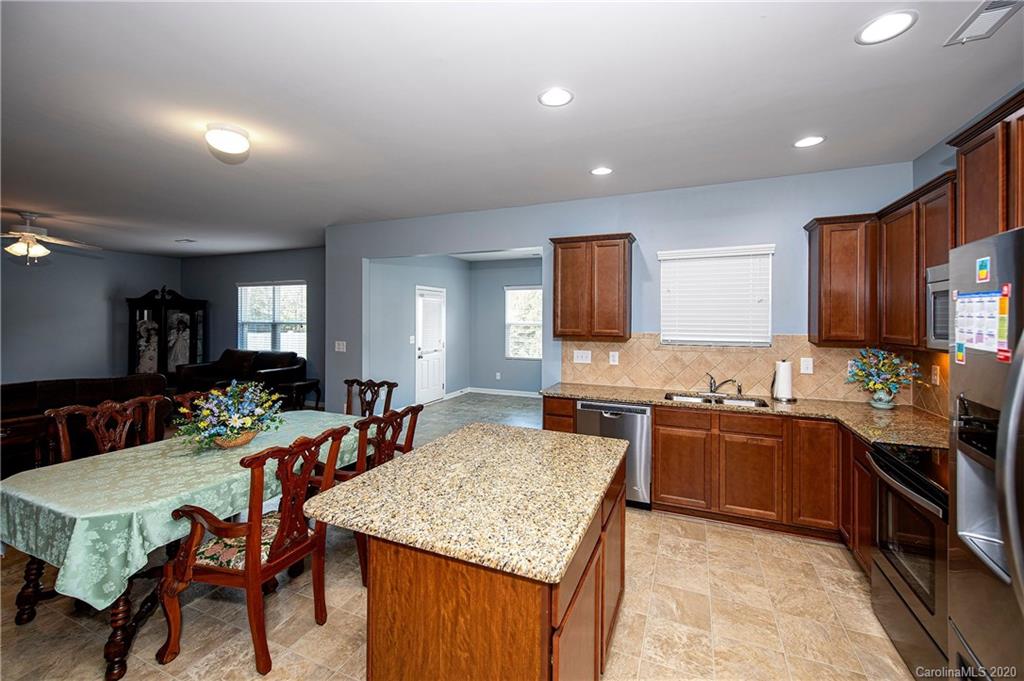 9915 Paper Tree Road Charlotte, NC 28227 - Photo 11 of 35 a large kitchen with kitchen island a sink table and chairs