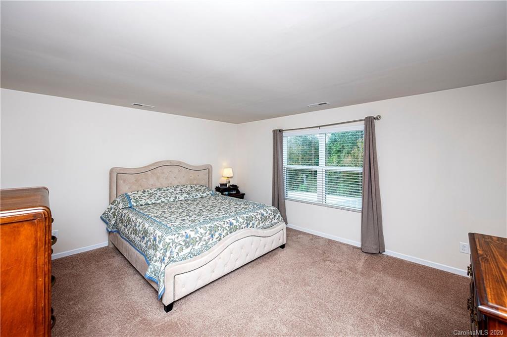 9915 Paper Tree Road Charlotte, NC 28227 - Photo 17 of 35 a bedroom with a bed lamp and a window