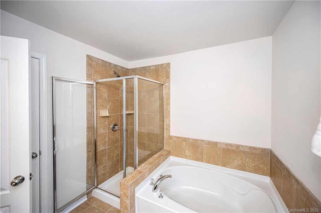 9915 Paper Tree Road Charlotte, NC 28227 - Photo 22 of 35 a bathroom with a white bath tub a shower and a sink
