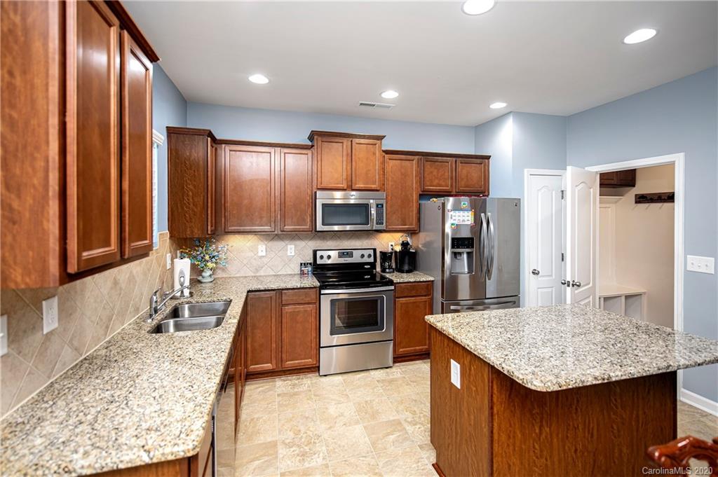 9915 Paper Tree Road Charlotte, NC 28227 - Photo 10 of 35 a kitchen with stainless steel appliances granite countertop granite counter tops refrigerator a stove top oven and granite countertops