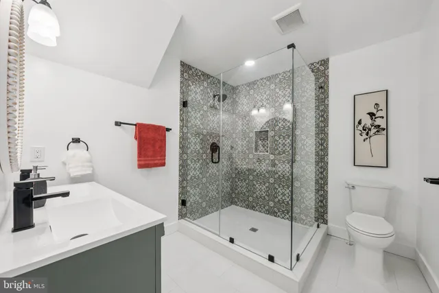 a bathroom with a sink a toilet and shower