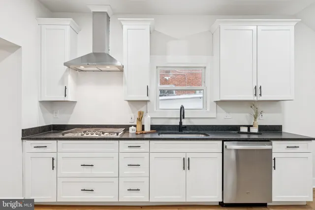 a kitchen with granite countertop white cabinets and a stainless steel appliances