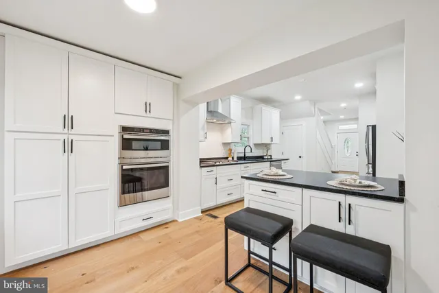 a kitchen with white cabinets and white appliances