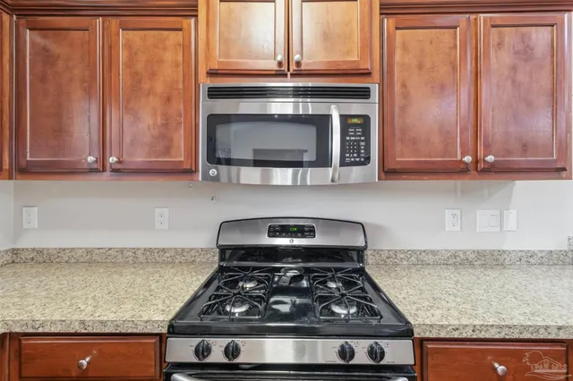 a kitchen with granite countertop a stove and a microwave