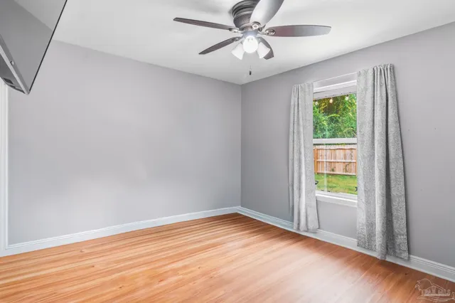 wooden floor in an empty room with a window