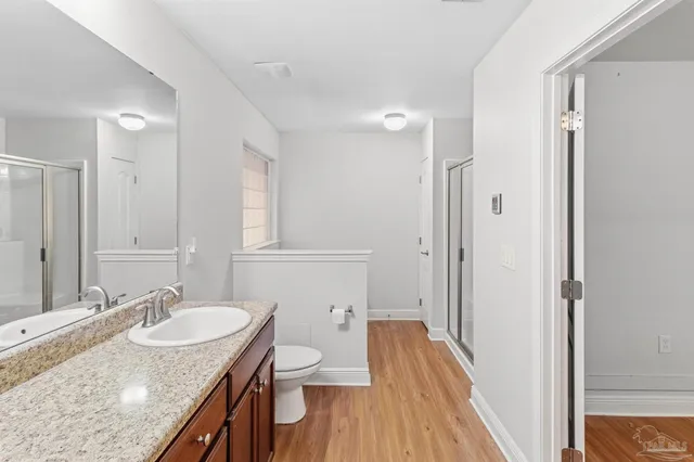 a bathroom with a granite countertop sink a mirror and a toilet