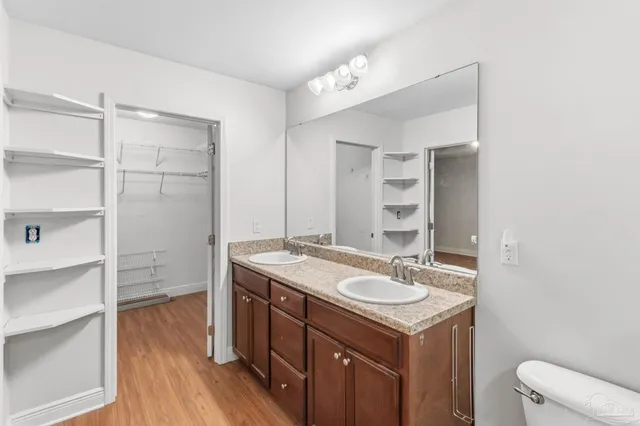 a bathroom with a sink toilet double vanity and tub