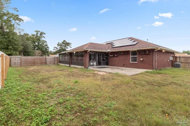 a view of a house with a yard and wooden fence