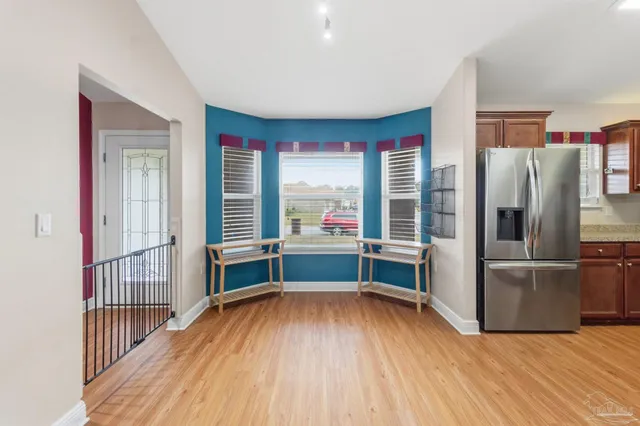 a view of a kitchen with wooden floor and electronic appliances