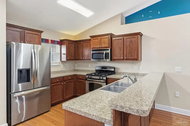a kitchen with stainless steel appliances granite countertop a refrigerator stove microwave and sink
