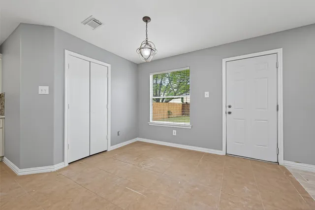 an empty room with windows and closet