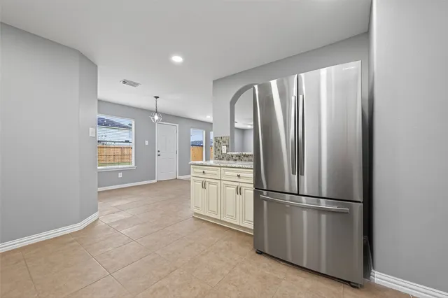 a kitchen with refrigerator and cabinets
