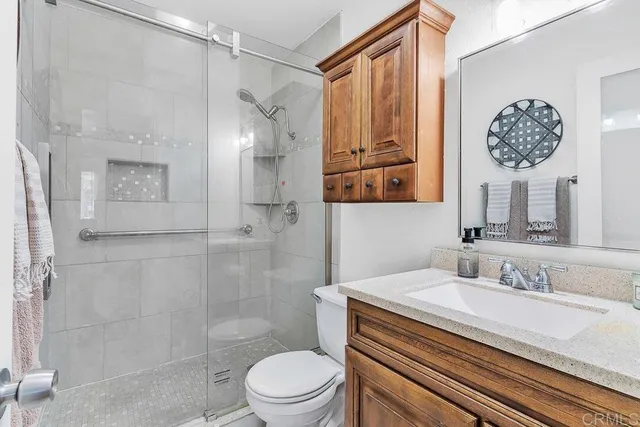 a bathroom with a sink a toilet and shower