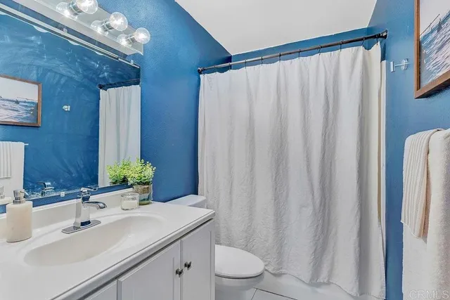 a bathroom with a sink a toilet and shower curtain