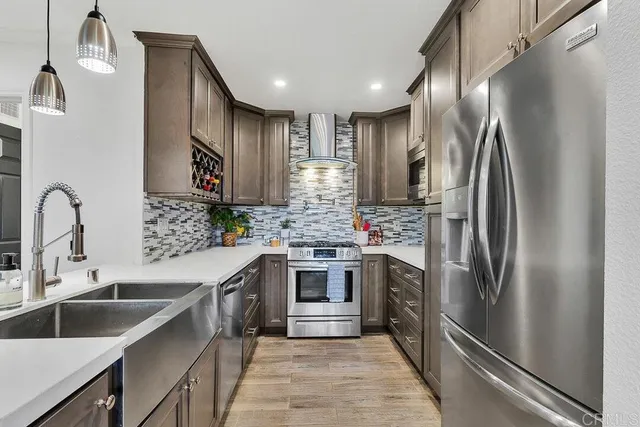 a kitchen with kitchen island stainless steel appliances cabinets a sink and a stove