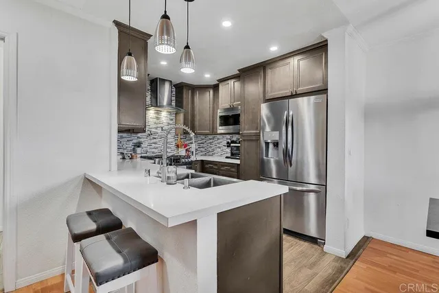 a kitchen with stainless steel appliances a refrigerator sink and microwave