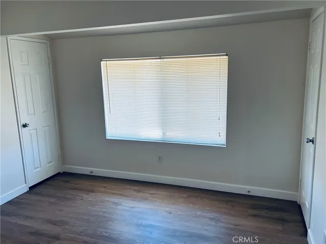 a view of a small space with wooden floor and a window