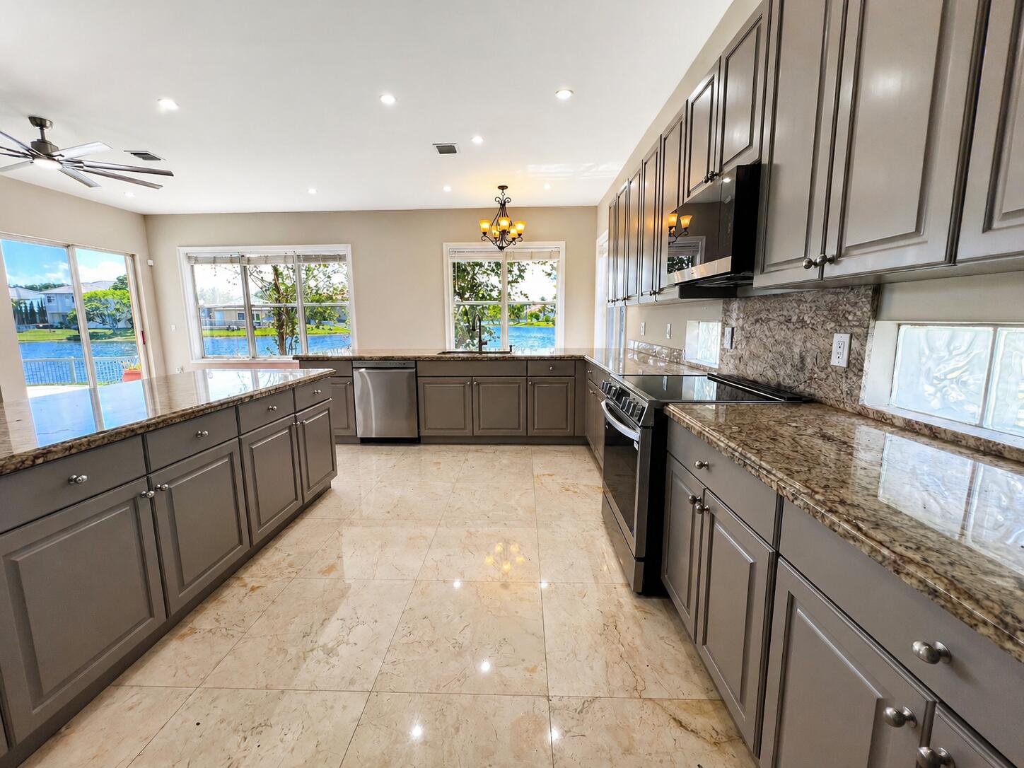 13196 Southwest 29th Street Miramar, FL 33027 - Photo 46 of 71 a kitchen with stainless steel appliances granite countertop a refrigerator a stove top oven a sink dishwasher and wooden cabinets with wooden floor