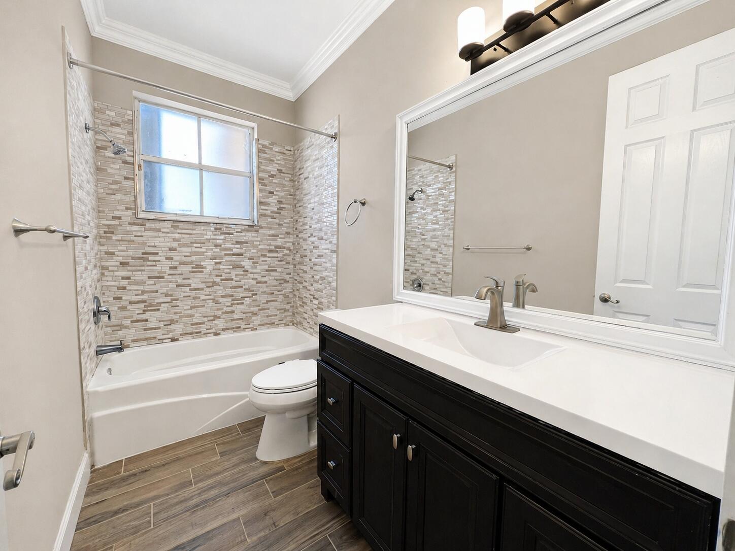 13196 Southwest 29th Street Miramar, FL 33027 - Photo 65 of 71 a bathroom with a granite countertop toilet a sink a mirror a bathtub and shower