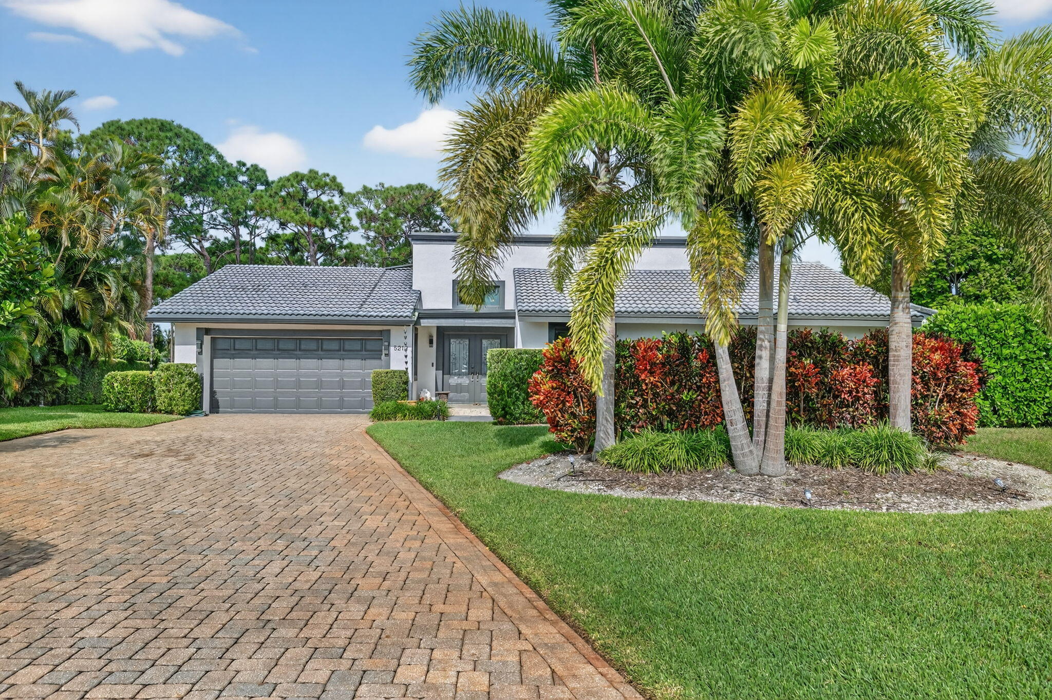 a front view of a house with a yard and potted plants