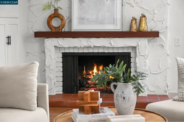 a living room with furniture a fireplace and a large mirror with wooden floor
