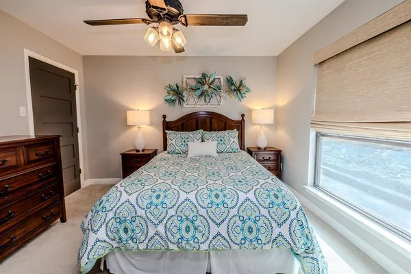 a bedroom with a bed a chandelier and a dresser