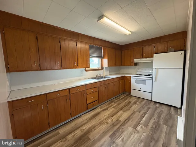 a kitchen with wooden cabinets and white appliances