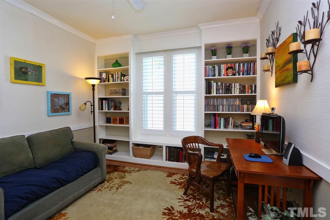 5944 Sentinel Drive Raleigh, NC 27609 - Photo 14 of 24 a living room with furniture a rug and a book shelf