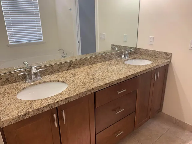 a bathroom with a granite countertop sink and a mirror