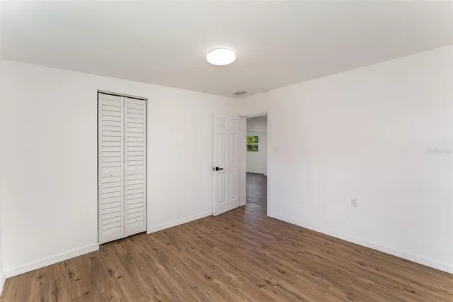 an empty room with wooden floor and white walls