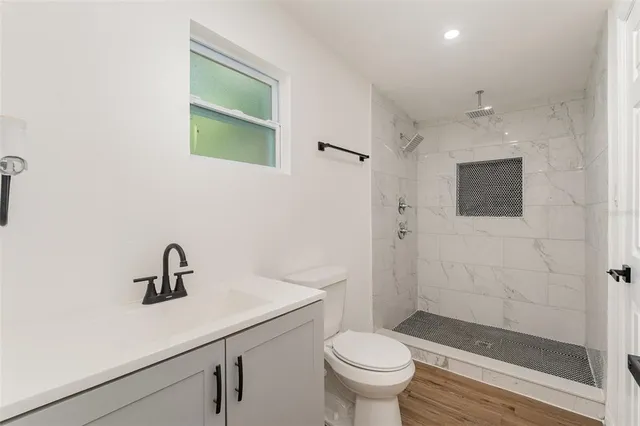 a bathroom with a sink a toilet and shower