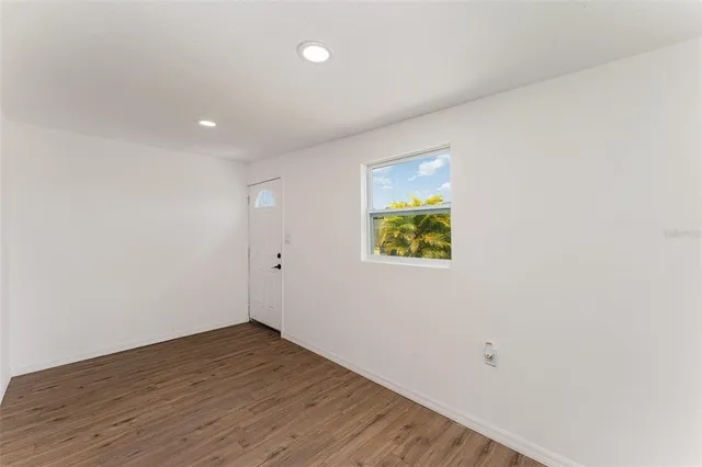 a view of an empty room with wooden floor