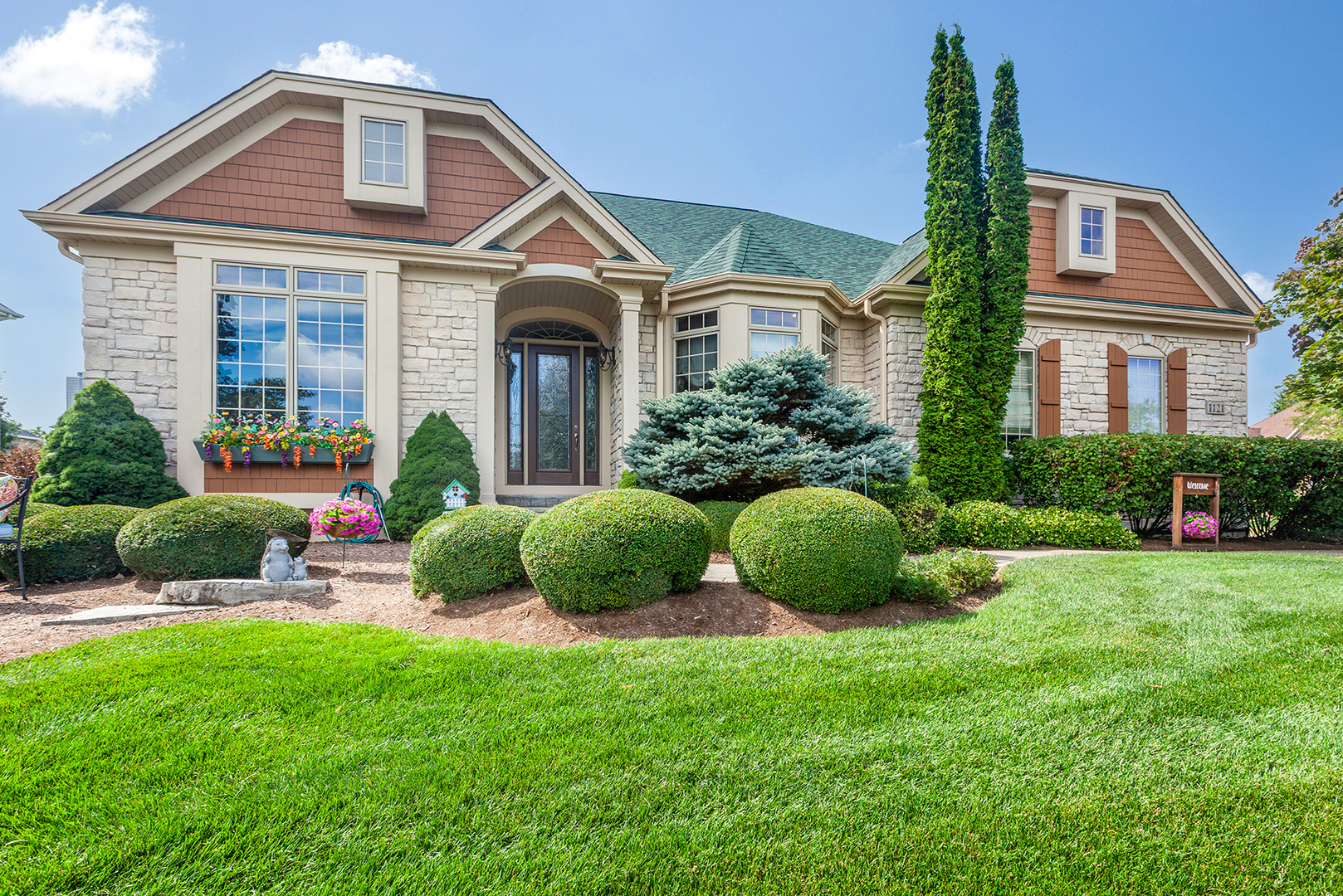 a front view of a house with a yard and potted plants