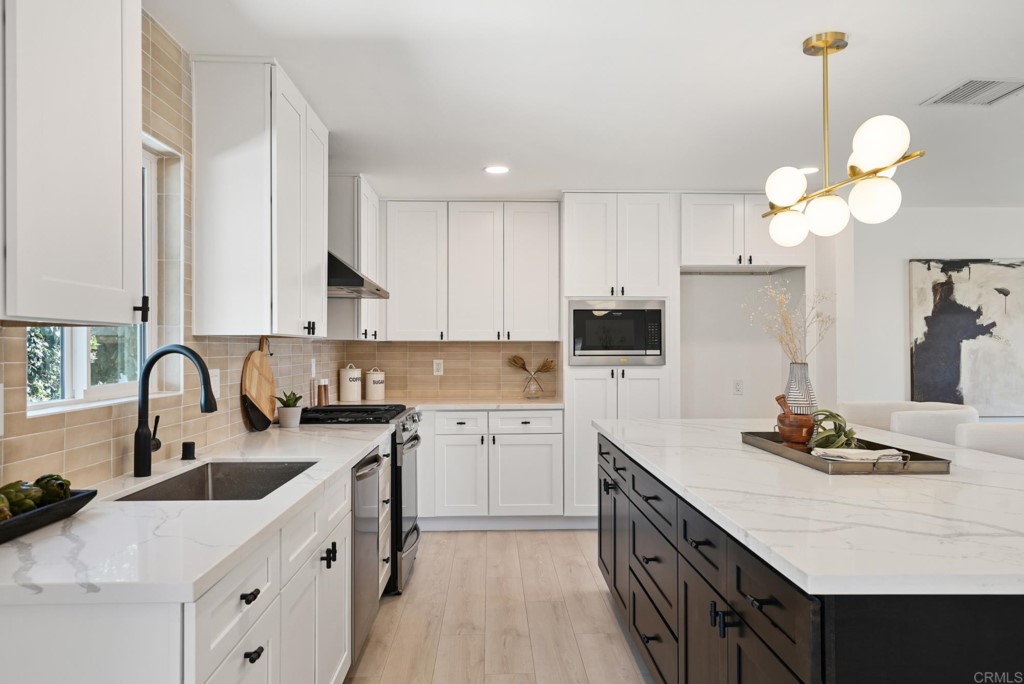 6125 Laport Street La Mesa, CA 91942 - Photo 13 of 32 a kitchen with a sink dishwasher a stove top oven a counter space and cabinets
